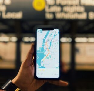 pexels-photo-14629408-14629408 A person holds a smartphone displaying a map of NYC inside a subway station.